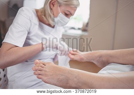 Pedicurist Doing Professional Medical Pedicure Procedure In Beauty Salon With Special Eguipment. Foo
