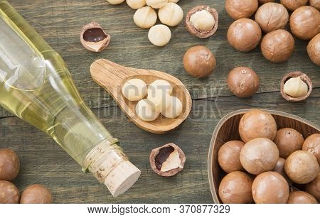 Nuts And Macadamia Oil On Wooden Background - Macadamia Integrifolia
