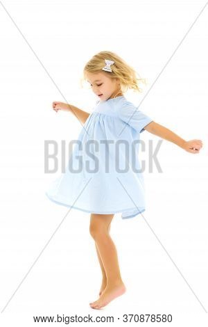 Beautiful Little Girl In A Dress Is Spinning. Concept Of Happy Childhood, Dancing, Holidays. Isolate