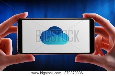 Poznan, Pol - May 21, 2020: Hands Holding Smartphone Displaying Logo Of Microsoft Onedrive, A File H