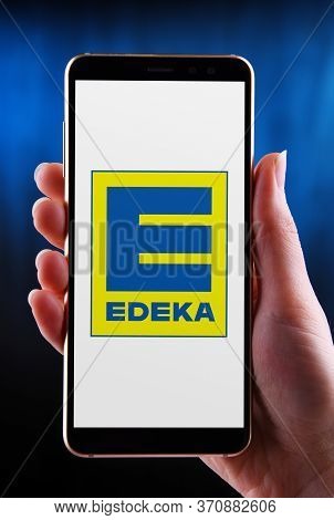 Poznan, Pol - May 21, 2020: Hands Holding Smartphone Displaying Logo Of Edeka, The Largest German Su