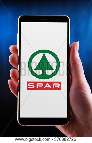 Poznan, Pol - May 21, 2020: Hands Holding Smartphone Displaying Logo Of Spar, A Dutch Multinational 