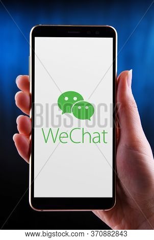 Hands Holding Smartphone Displaying Logo Of Wechat