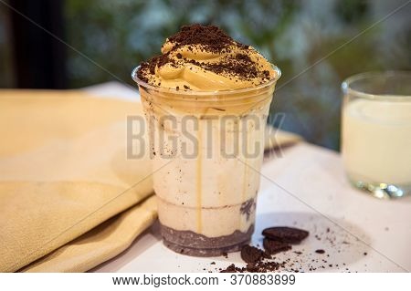 Homemade Dalgona Whipped Coffee With Cookies Crump In A Cup On A White Table With A Cup Of Milk Blur