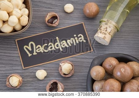 Nuts And Macadamia Oil On Wooden Background - Macadamia Integrifolia