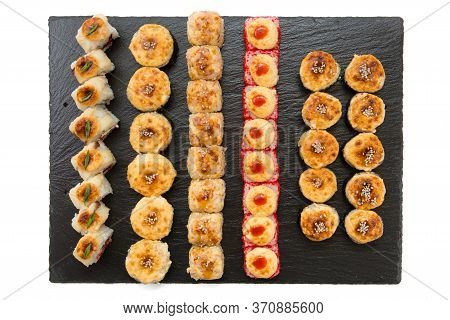 Set Of Fried Sushi Rolls With Fish And Rice On Black Stone Slate