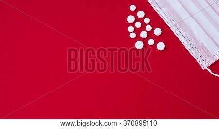 Medikal Mask And White Tablets On The Red Background
