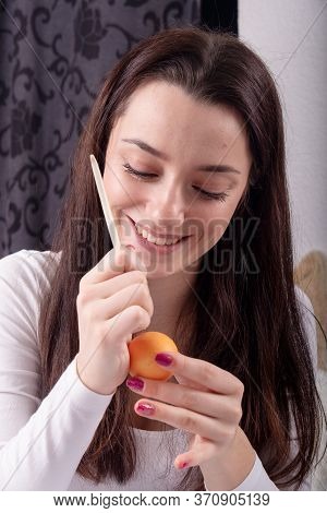 Young Beautiful Sexy German Woman With Dark Hair Paints An Orange Easter Egg According To Sorbian Tr