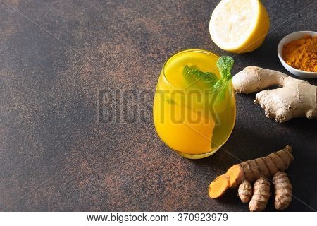 Jamu Indonesian Herbal Beverage With Natural Ingredients Turmeric, Ginger, Lemon On Brown Background