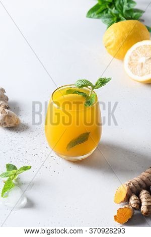 Jamu Indonesian Freshness Drink With Ice Cube, Turmeric, Ginger, Lemon On White Background. Close Up