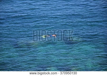 Man Floating On Surface Of Blue Ocean Water Near Catania, Sicily