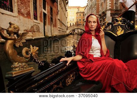Bella donna in mantello rosso cavalcando gandola