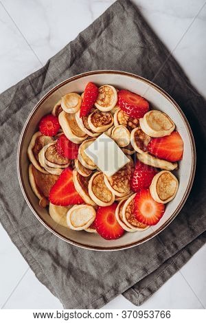 Trendy Home Breakfast With Tiny Cereal Pancakes With Piece Of Butter And Fresh Strawberries In The B