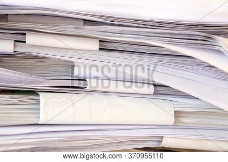 Stack Of Business Report Paper Files On Desk