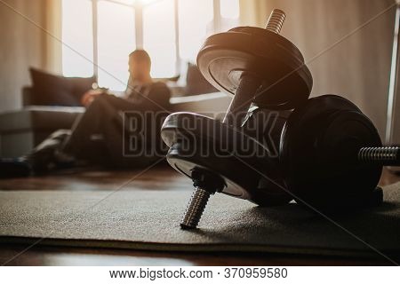 Young Ordinary Man Go In For Sport At Home. Dark View On Tired Male Preson After Training Sit On Flo