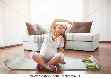 Pre-natal Exercise. Pregnant Woman Exercising At Home