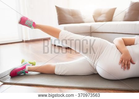 A Pregnant Woman Works Out On A Yoga Mat At Home. Pregnancy And Sports. Oga And Pilates For Pregnant