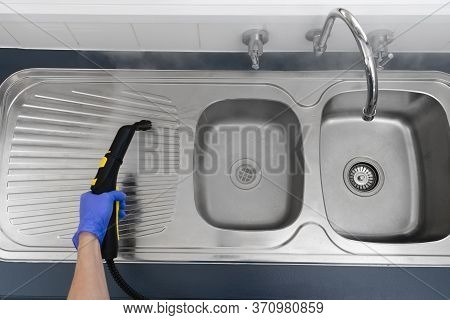 Top Down Shot Of Sanitizing Kitchen Sink With Steam Cleaner