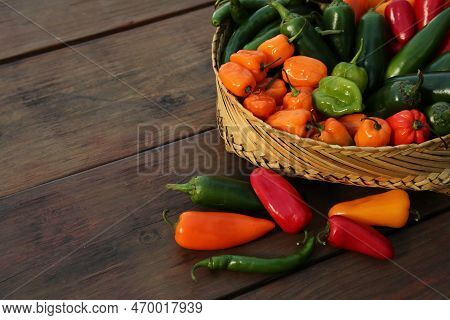 Many Different Fresh Chilli Peppers On Wooden Table, Space For Text