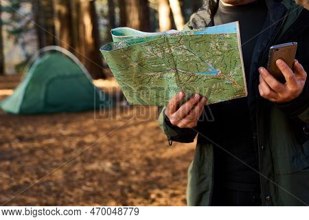 Adult Hiker With Backpack Using Mobile Phone And Map In Forest Near His Tent. Hiking Elderly Man In 