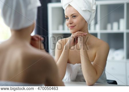 Young Woman Sits In The Bathroom In Front Of The Makeup Mirror And Does Cosmetic Procedures. Beautif