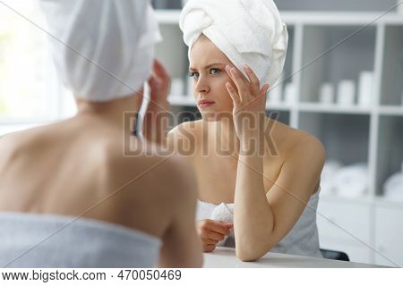 Young Woman Sits In The Bathroom In Front Of The Makeup Mirror And Does Cosmetic Procedures. Beautif