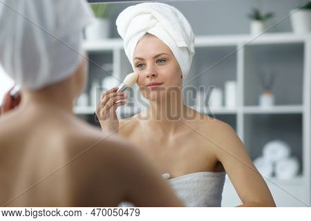 Young Woman Sits In The Bathroom In Front Of The Makeup Mirror And Does Cosmetic Procedures. Beautif