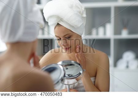 Young Woman Sits In The Bathroom In Front Of The Makeup Mirror And Does Cosmetic Procedures. Beautif