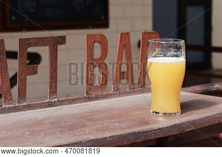 A Pint Of Unfiltered Apa On The Bar. A Glass Of Started Beer.