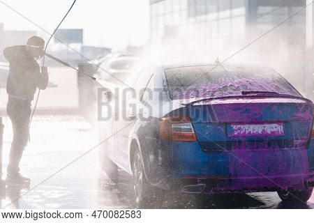 Process Of Man Washing His Car In A Self-service Car Wash Station. Back View