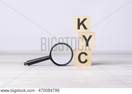 Concept Know Your Customer Or Kyc. Text On Wooden Cubes Under A Magnifying Glass.