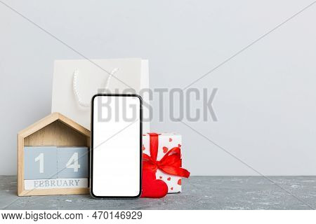 Mobile Phone With Blank Screen On Colored Background With Hearts, Calendar And Gift Box, Valentine D