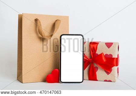 Mobile Phone With Blank Screen On Colored Background With Hearts, Calendar And Gift Box, Valentine D