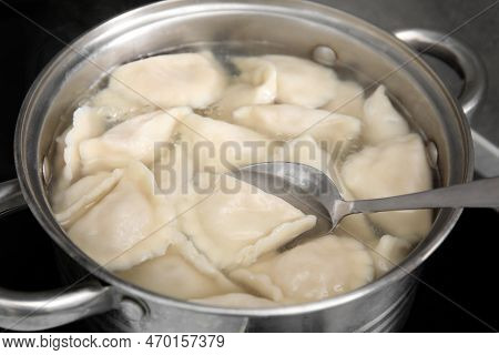 Cooking Dumplings (varenyky) With Tasty Filling In Pot Indoors, Closeup