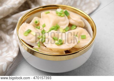 Cooked Dumplings (varenyky) With Tasty Filling And Green Onion On Light Table, Closeup
