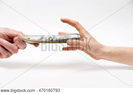 Man's Hand Offers Dollar Bribe, And A Woman Greedily Reaches For Money. Close-up. Concept Of Bribery