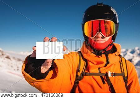 Snowboarder Or Skier Holding Blank Lift Pass In Hand, Portrait With Mountain In The Background. Ski 