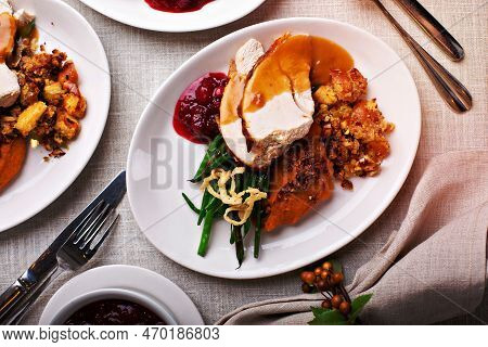 Festive Thankgiving Dinner Table With Plates Of Food, Turkey And All The Sides