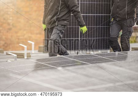 The Process Of Installing Solar Panels. Solar Panel Installers Work On The Roof. Installers Carry So