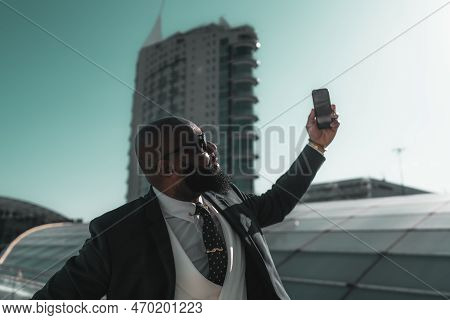 A Portrait Of A Black, Unshaven, And Bald Male, Looking Dapper In His Tailored Suit Taking A Selfie 