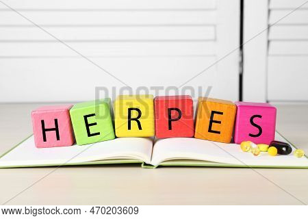 Word Herpes Made Of Colorful Cubes, Open Book And Pills On Beige Table