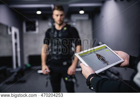 Showing The Results Of Electronic Muscle Stimulation Training On A Special Tablet. Shot Of Male Hand
