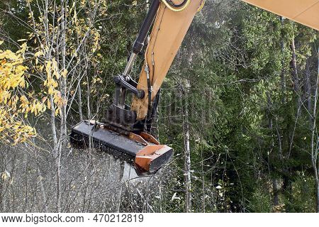 Mulching Vegetation On Side Of Road In Wooded Area With An Excavator With Mulching Head.