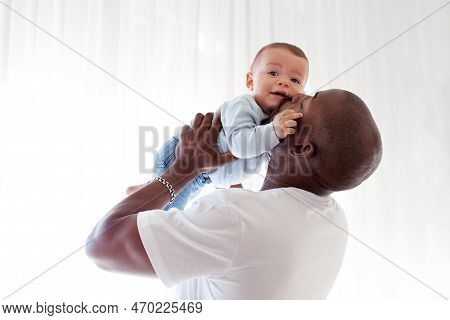 African American Black Dad Kisses, Holds On Arms And Loves Baby Son Mixed Race Child Against White B