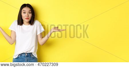 Clueless Asian Girl Shrugging Shoulders, Spread Out Hands And Looking Confused, Know Nothing, Standi