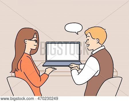 Smiling Colleagues Sit At Desk Working Together On Computer. Happy Employees Or Coworkers Cooperate 