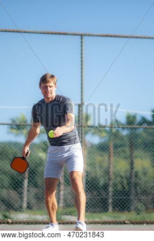 Man Playing Pickleball Game, Hitting Pickleball Yellow Ball With Paddle, Outdoor Sport Leisure Activ