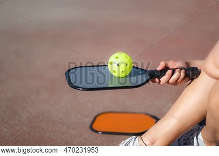 Pickleball Paddle And Yellow Ball Close Up, Woman Playing Pickleball Game, Hitting Pickleball Yellow