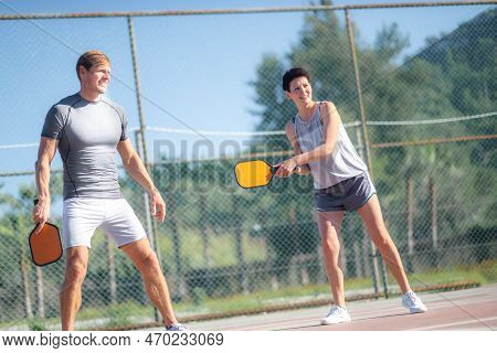 Couple Playing Pickleball Game, Hitting Pickleball Yellow Ball With Paddle, Outdoor Sport Leisure Ac