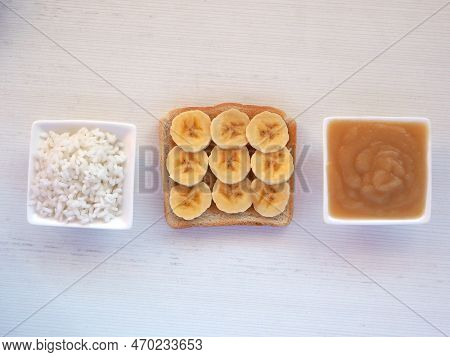 Toast With Banana Slices, Rice, And Applesauce On A White Background. Food Of Brat Diet While Diarrh